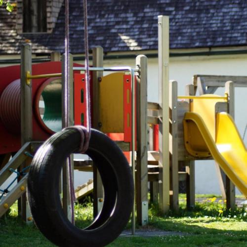 Reifenschaukel mit Spielgerüst im Hintergrund